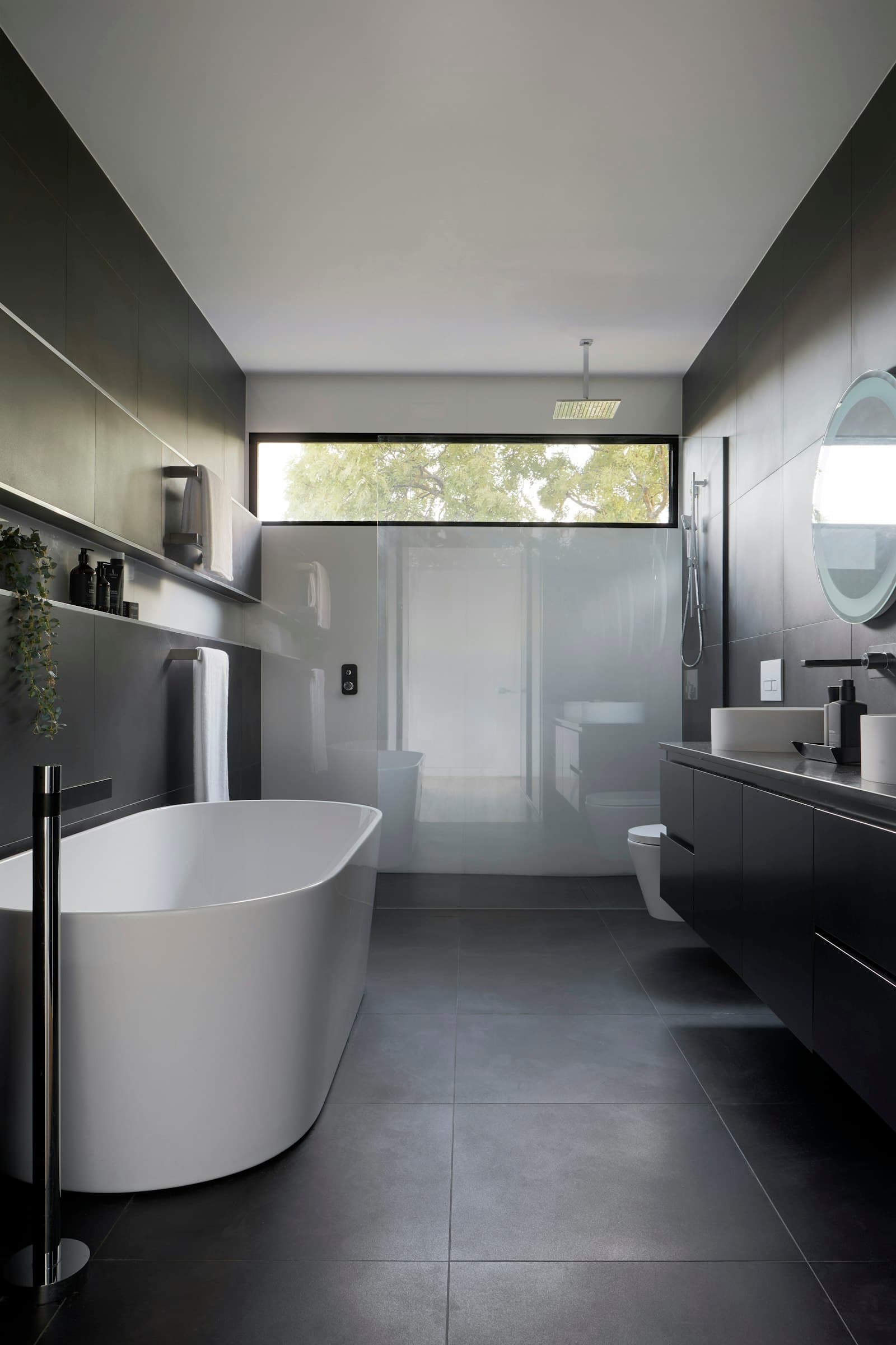 Dark, spa-like bathroom with a freestanding tub and walk-in shower
